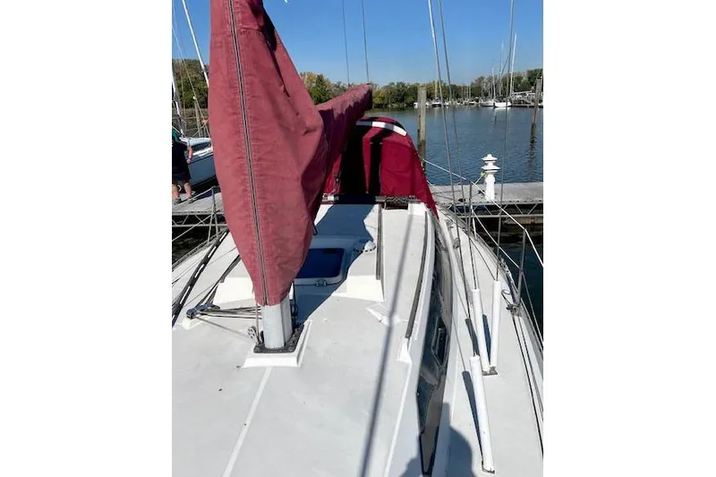 Slide: The Image of 1988 O'Day 322 sailboat with red sails docked at a marina. - 5