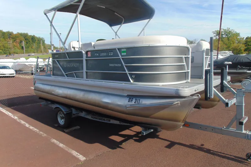 Slide: The Image of 2022 Godfrey Sweetwater 1680 CX pontoon boat on trailer, parked outdoors. - 3