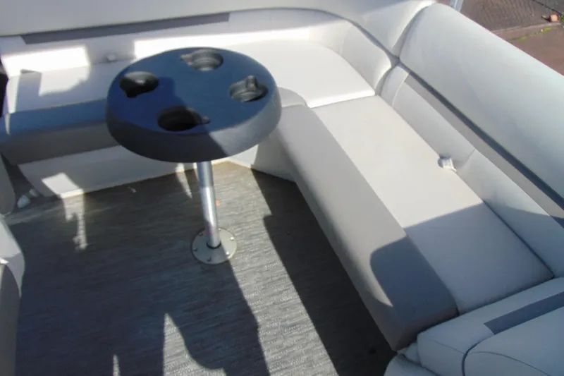 Slide: The Image of 2022 Godfrey Sweetwater 1680 CX boat interior with cushioned seating and cup holder table. - 9