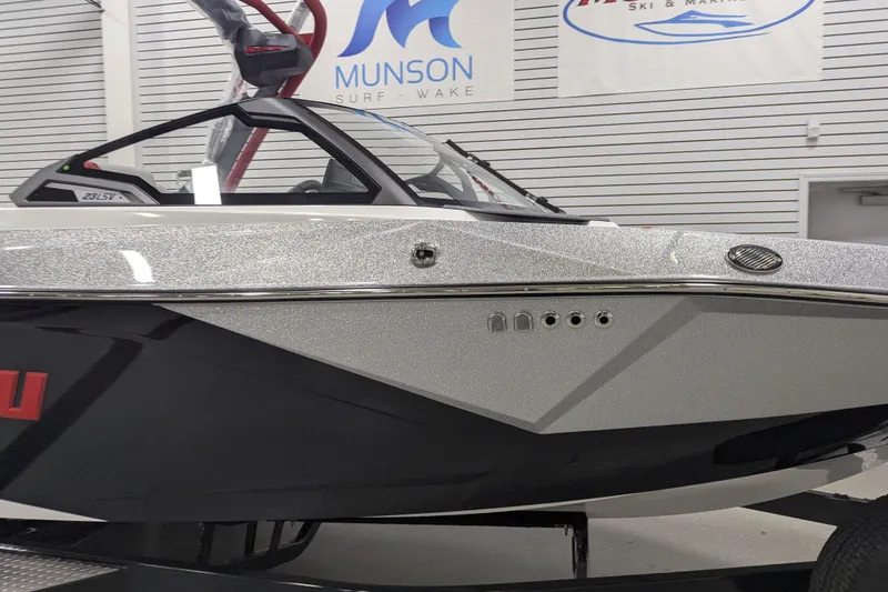 Slide: The Image of 2026 Malibu Wakesetter 23 LSV boat in showroom, featuring sleek design and metallic finish. - 21