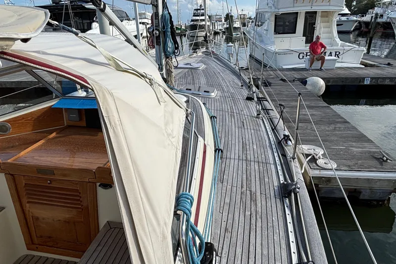 Slide: The Image of 1992 Najad 390 sailboat docked at marina, showcasing wooden deck and cabin details. - 23