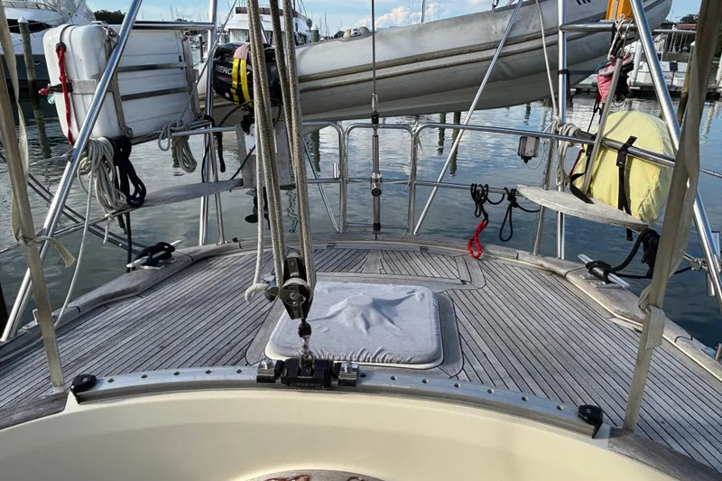 Slide: The Image of 1992 Najad 390 sailboat deck with lifebuoy and ropes in marina setting. - 28