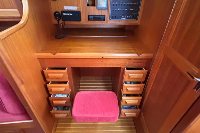 Slide: The Image of Interior of 1992 Najad 390 yacht with wooden desk, drawers, and red cushioned stool. - 37