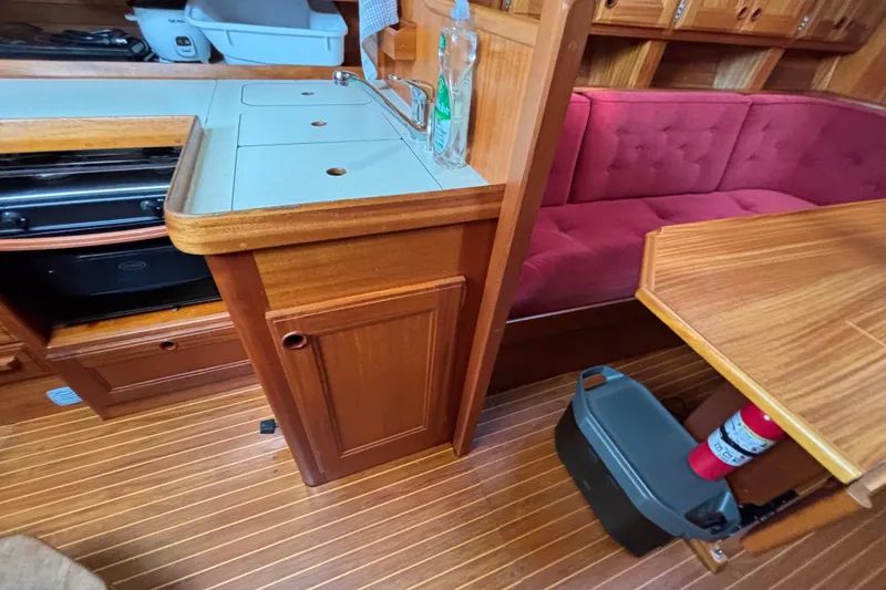 Slide: The Image of Interior of 1992 Najad 390 yacht with wooden cabinetry, red seating, and compact kitchen area. - 39