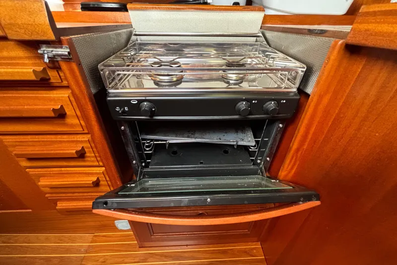 Slide: The Image of Stove and oven in 1992 Najad 390 yacht kitchen, featuring wooden cabinetry. - 44