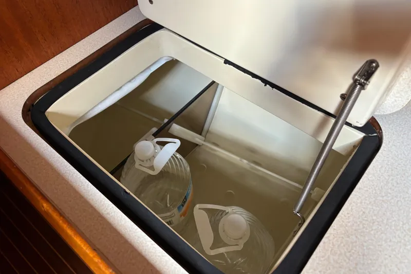 Slide: The Image of Storage compartment with water bottles inside a 1992 Najad 390 yacht. - 46