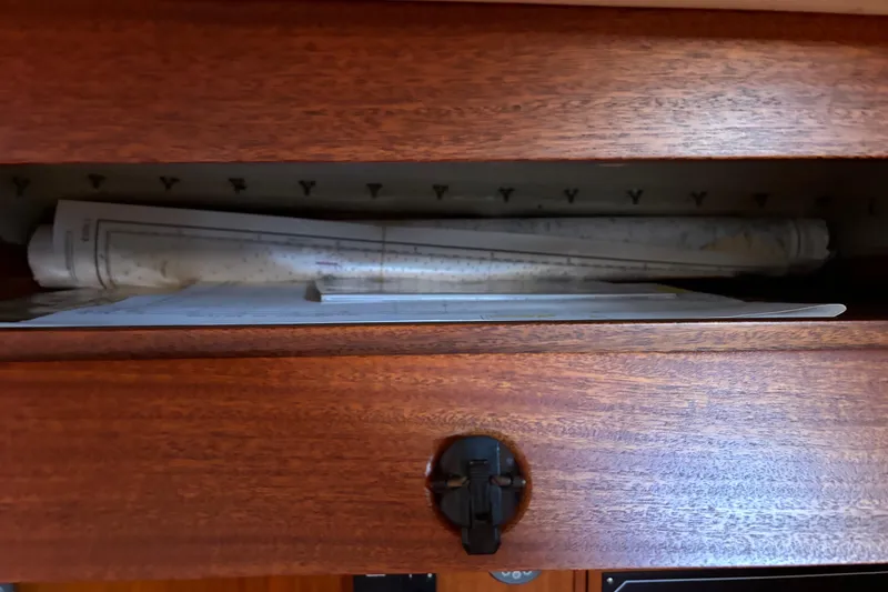 Slide: The Image of Wooden cabinet with rolled nautical charts inside, aboard a 1992 Najad 390 sailboat. - 48