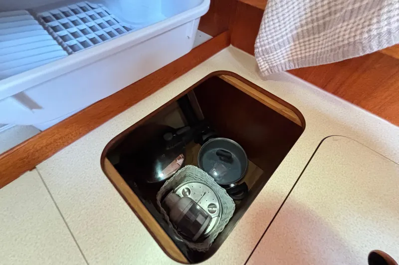 Slide: The Image of Storage compartment in a 1992 Najad 390 yacht galley with cookware and utensils. - 52