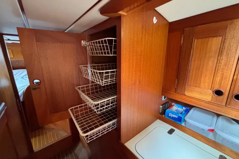 Slide: The Image of Interior of 1992 Najad 390 yacht with wooden cabinetry and wire storage baskets. - 54