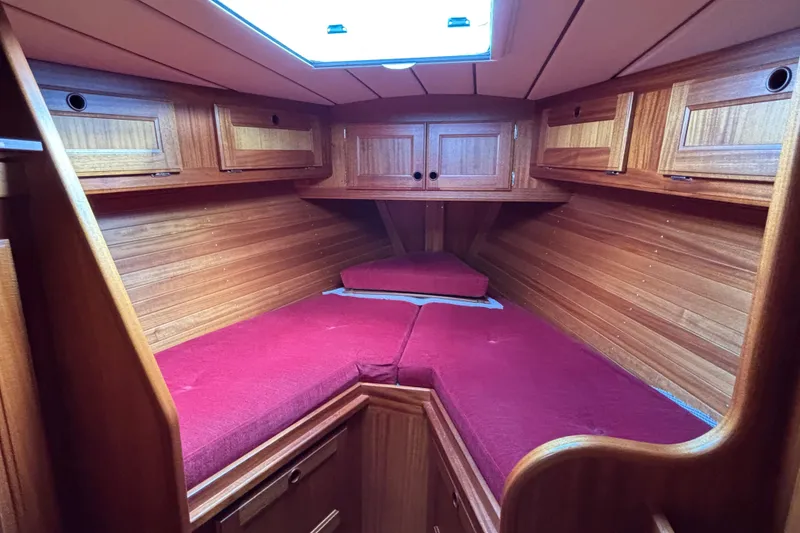 Slide: The Image of Cozy cabin interior of a 1992 Najad 390 sailboat with red cushions and wooden cabinetry. - 65