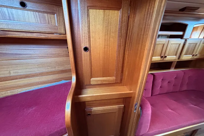 Slide: The Image of Interior of 1992 Najad 390 yacht with wooden cabinetry and red cushioned seating. - 68