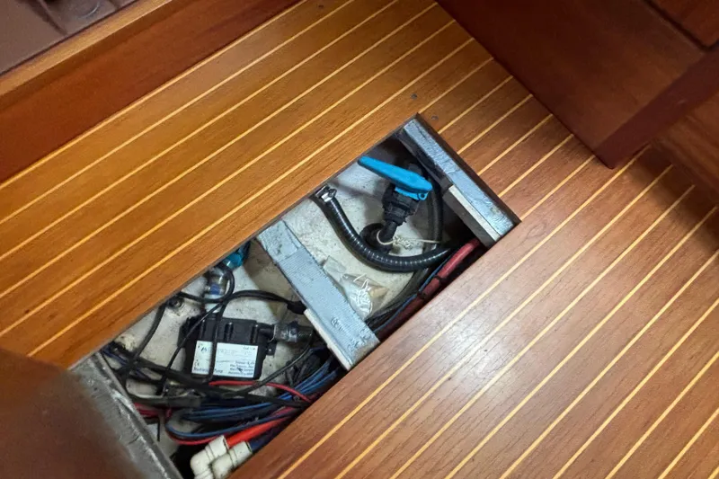Slide: The Image of Wooden floor panel open, revealing Najad 390 yacht's underfloor wiring and plumbing, 1992 model. - 71