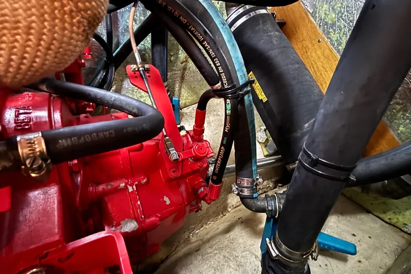 Slide: The Image of Engine compartment of a 1992 Najad 390 sailboat with visible hoses and components. - 74