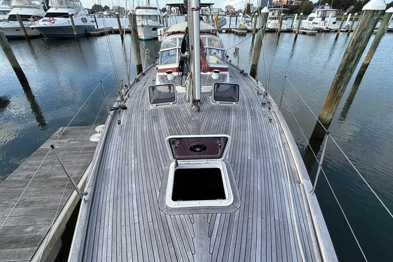 Slide: The Image of 1992 Najad 390 sailboat deck view at marina, showcasing open hatches and wooden finish. - 78