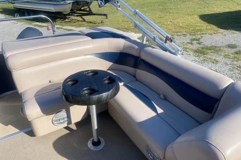 Slide: The Image of 2014 Godfrey SWEETWATER 2086 boat interior with beige seating and cup holder table. - 8