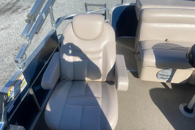 Slide: The Image of 2014 Godfrey SWEETWATER 2086 boat interior with beige seating and steering area. - 9