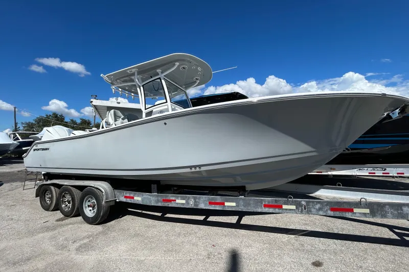 The Image of 2019 Sportsman Open 282 Center Console boat on trailer under clear blue sky. - 0