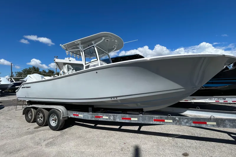 Slide: The Image of 2019 Sportsman Open 282 Center Console boat on trailer under clear blue sky. - 1