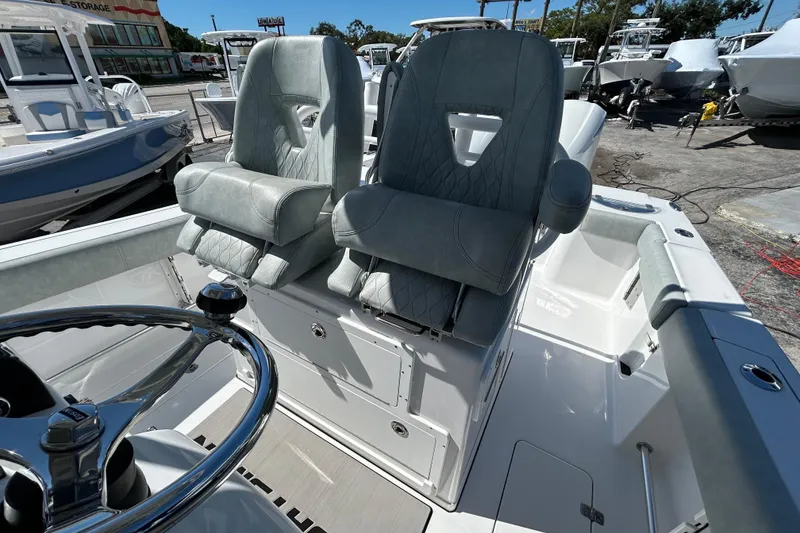 Slide: The Image of 2019 Sportsman Open 282 Center Console boat interior with dual seats and steering wheel. - 16