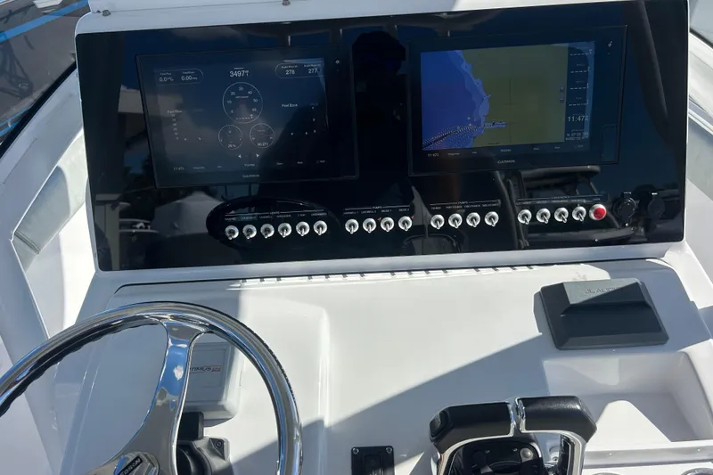Slide: The Image of 2019 Sportsman Open 282 Center Console dashboard with dual Garmin displays and controls. - 25