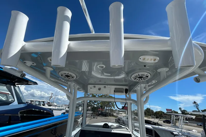 Slide: The Image of 2019 Sportsman Open 282 Center Console boat with rod holders and speakers under a clear blue sky. - 28