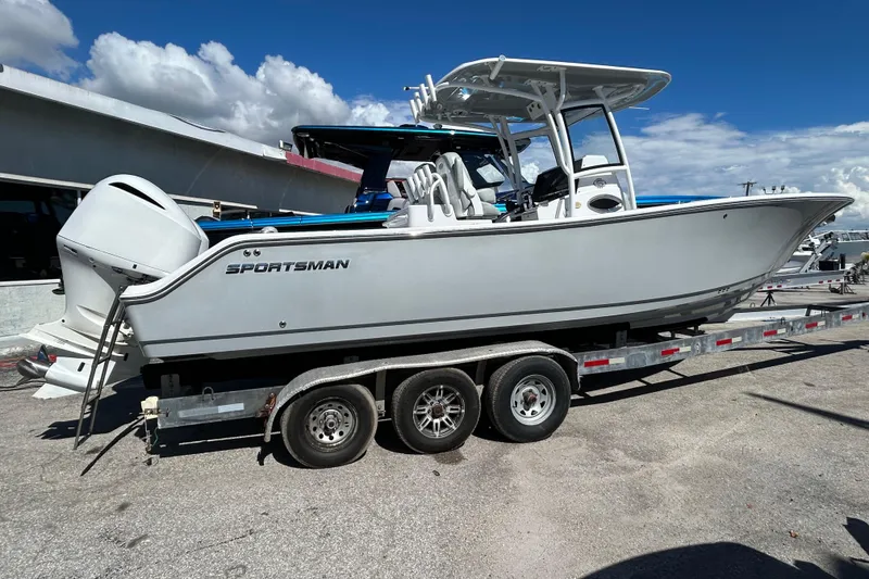 Slide: The Image of 2019 Sportsman Open 282 Center Console boat on a trailer under a clear blue sky. - 4