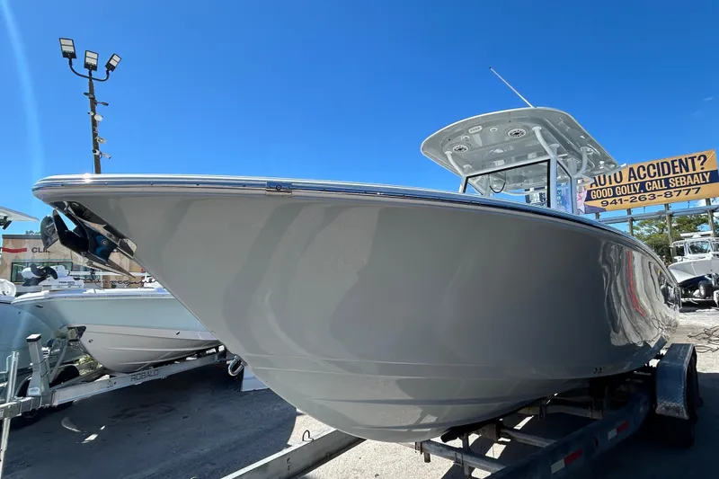 Slide: The Image of 2019 Sportsman Open 282 Center Console boat on trailer under clear blue sky. - 5