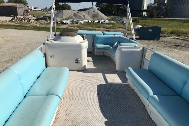 Slide: The Image of 2006 Sunset Bay CRUISE DELUXE pontoon boat with blue seating, parked outdoors. - 11