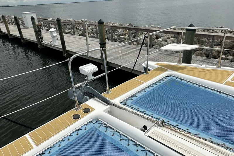 Slide: The Image of 2007 Manta 44 Power Cat docked, featuring blue netting and wooden deck details. - 35