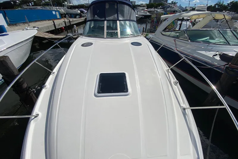 Slide: The Image of 2002 Sea Ray 320 Sundancer docked at marina, showcasing sleek deck design. - 14