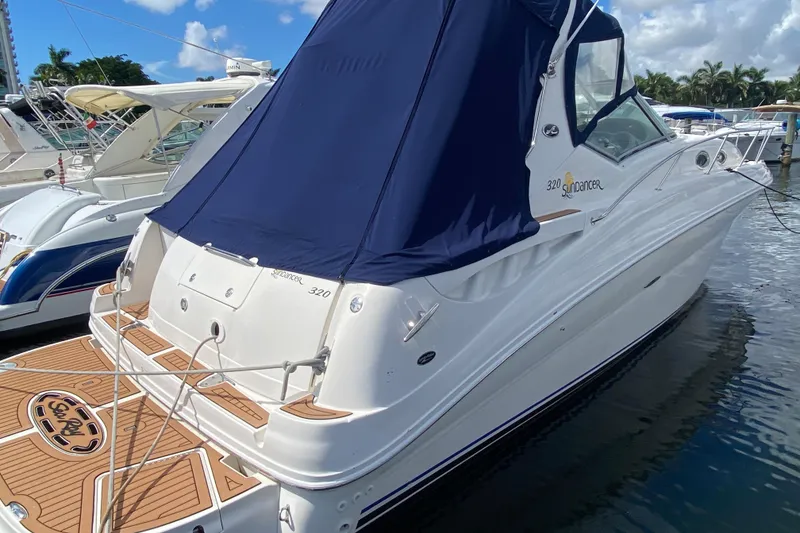 Slide: The Image of 2002 Sea Ray 320 Sundancer boat docked with blue canopy and teak deck. - 21
