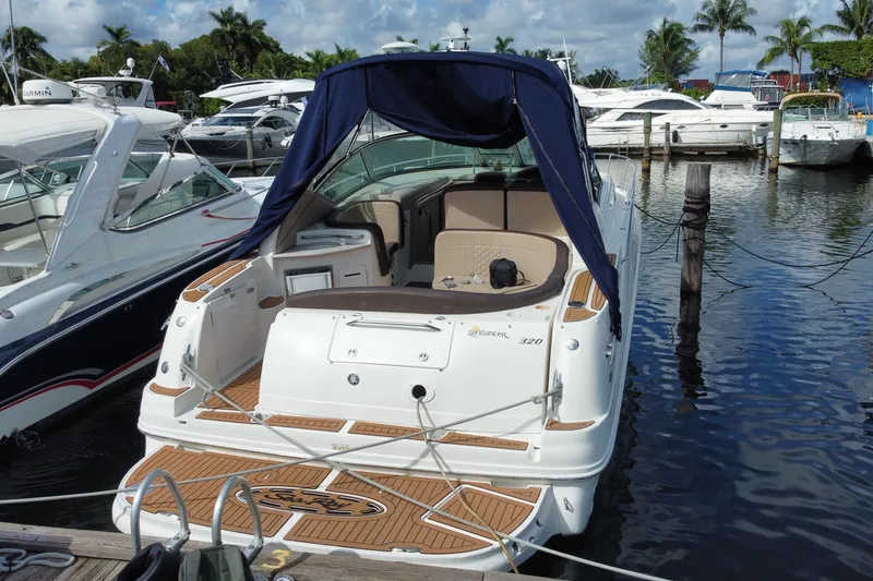 Slide: The Image of 2002 Sea Ray 320 Sundancer docked at marina, featuring sleek design and spacious deck. - 22