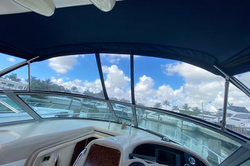 Slide: The Image of Cockpit view of 2002 Sea Ray 320 Sundancer with marina backdrop and blue sky. - 34