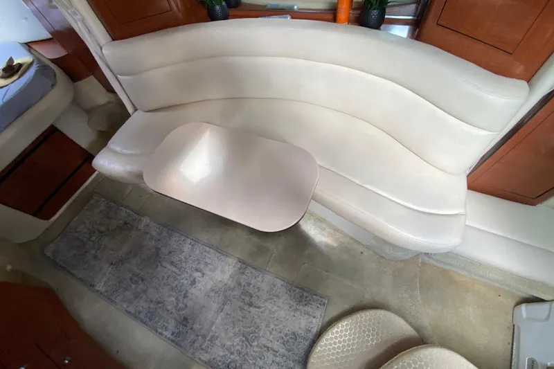 Slide: The Image of Interior of 2002 Sea Ray 320 Sundancer with curved seating and table. - 38