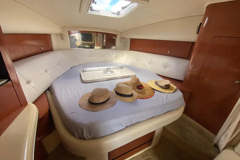 Slide: The Image of Luxurious cabin interior of 2002 Sea Ray 320 Sundancer with hats on bed. - 40