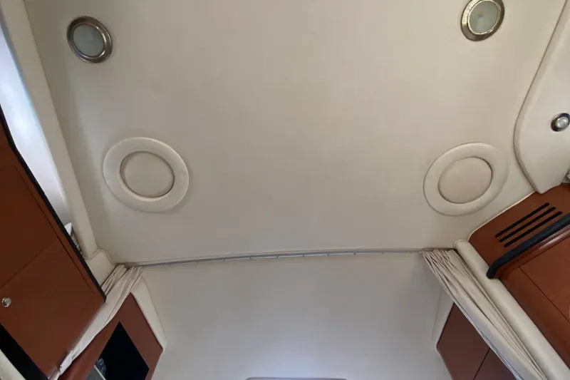 Slide: The Image of Interior ceiling of 2002 Sea Ray 320 Sundancer boat with circular lights and wood accents. - 42
