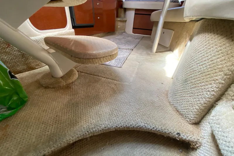 Slide: The Image of Interior of 2002 Sea Ray 320 Sundancer with carpeted flooring and wooden cabinetry. - 45