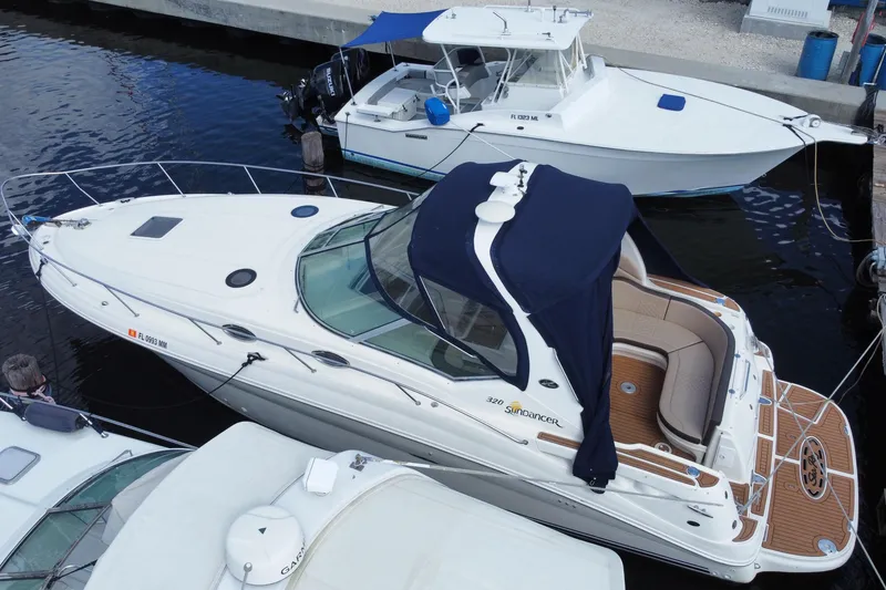 Slide: The Image of 2002 Sea Ray 320 Sundancer docked, featuring sleek design and spacious deck. - 5