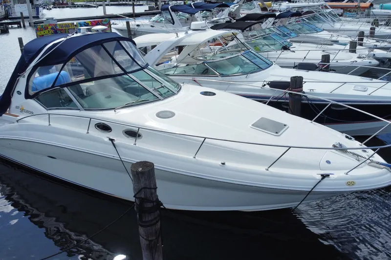 Slide: The Image of 2002 Sea Ray 320 Sundancer docked among other boats at a marina. - 6