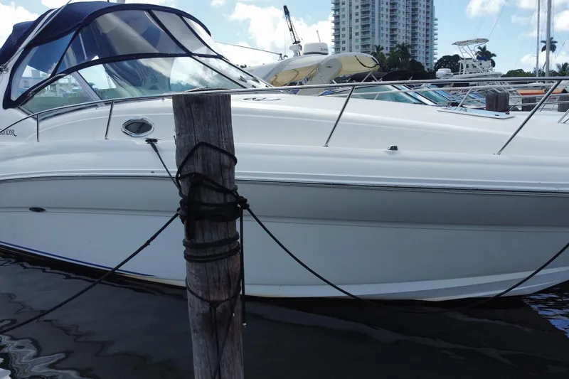 Slide: The Image of 2002 Sea Ray 320 Sundancer yacht docked at marina with cityscape background. - 8