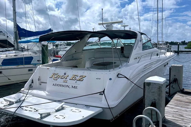 Slide: The Image of 1998 Searay SUNDANCER 450 yacht docked at marina under cloudy sky. - 12