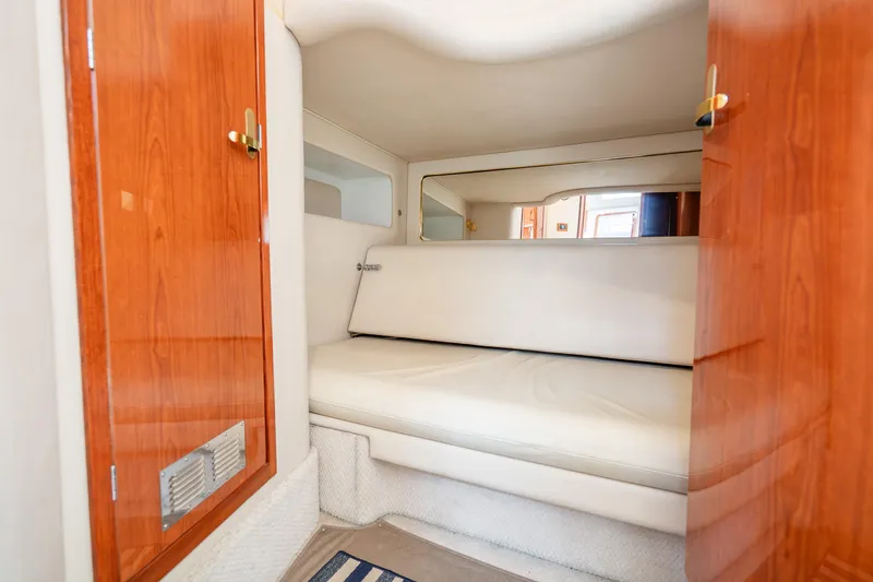 Slide: The Image of 1998 Sea Ray 450 Sundancer cabin interior with wooden accents and white seating. - 17