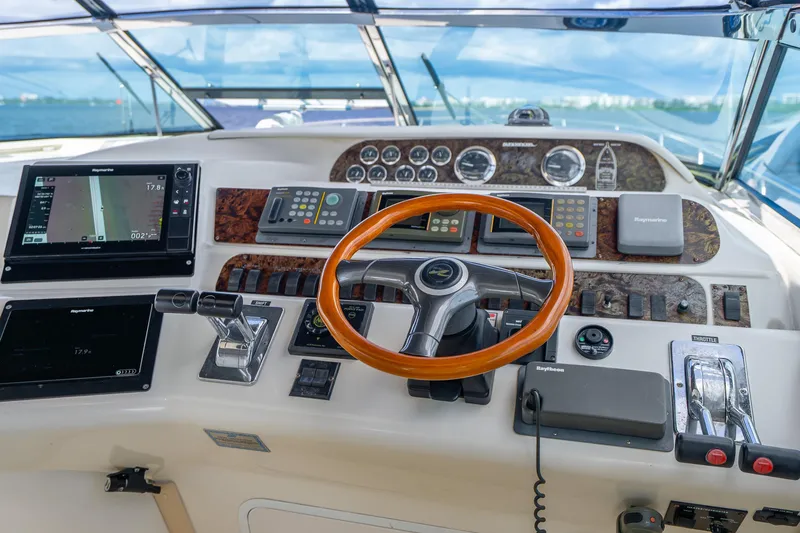 Slide: The Image of Cockpit of 1998 Sea Ray 450 Sundancer with navigation instruments and wooden steering wheel. - 25