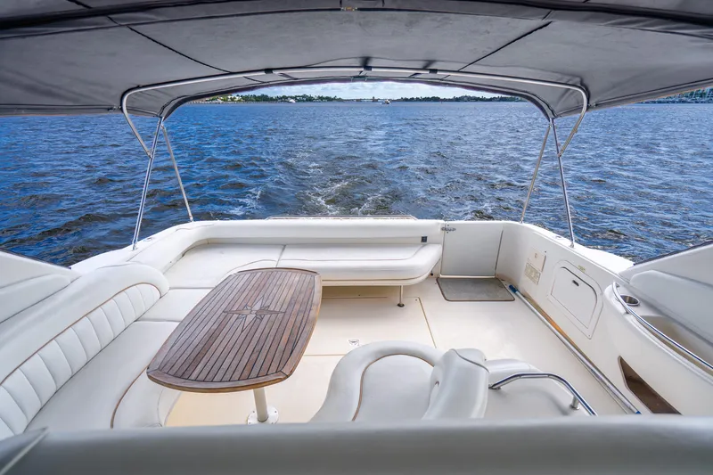 Slide: The Image of 1998 Sea Ray 450 Sundancer yacht interior with seating and table, overlooking the water. - 29