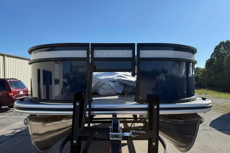 Slide: The Image of 2026 Lowe LF 194 pontoon boat on trailer under clear blue sky. - 2