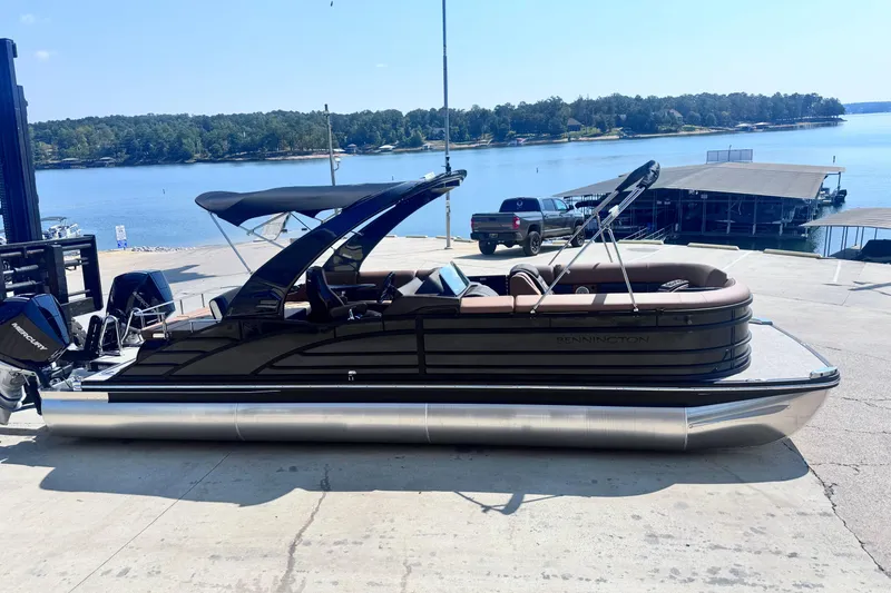 Slide: The Image of 2026 Bennington 27RSBAT2 pontoon boat docked by a scenic lake. - 8