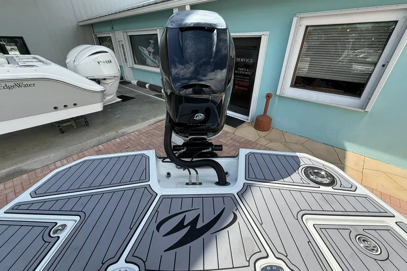 Slide: The Image of 2018 Monterey M-65 boat with outboard motor, docked near a blue building. - 15