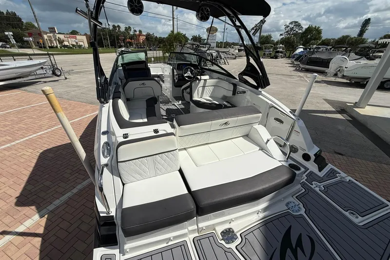 Slide: The Image of 2018 Monterey M-65 boat with sleek seating and modern design in a marina setting. - 18