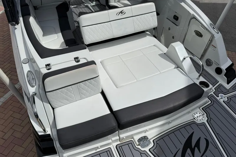 Slide: The Image of Luxury seating area on a 2018 Monterey M-65 boat, featuring sleek white and black upholstery. - 22