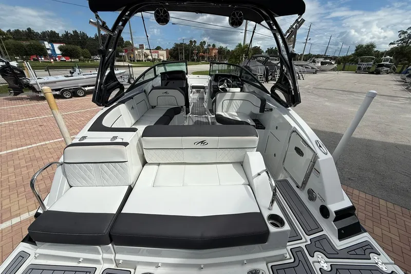 Slide: The Image of 2018 Monterey M-65 boat with spacious seating, sleek design, and modern features in a marina setting. - 23